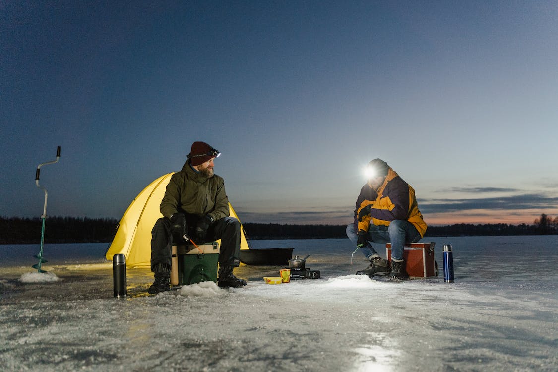 Free Men Fishing in a Frozen Lake Stock Photo
